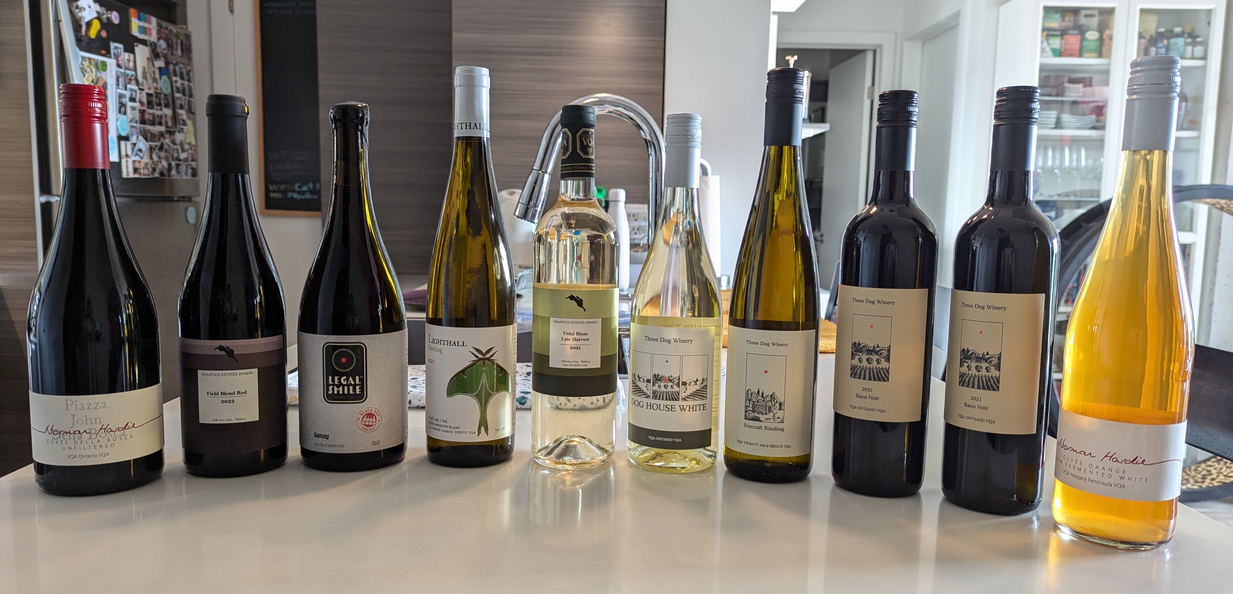 A row of wine bottles on a kitchen counter